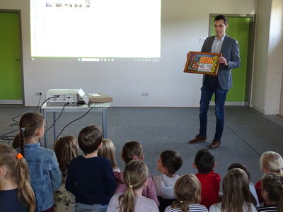 Bürgermeister Dr. Simon Haas überreicht den Lehrerinnen und Schülern der GS Haselbach...