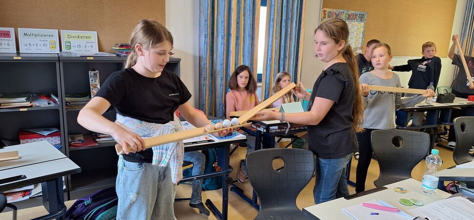 Schülerinnen spielen ein Spiel mit Kugeln