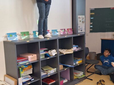 Ein Schüler steht auf einem Regal