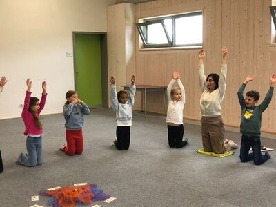 Kinder mit Frau Turhan bei einer Yogaübung