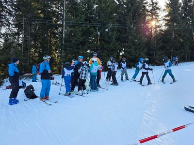 Eine Gruppe Schüler steht auf Skiern im Schnee