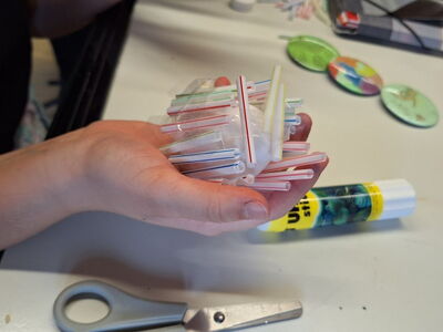 Bunte Strohhalme werden in einer Hand gehalten